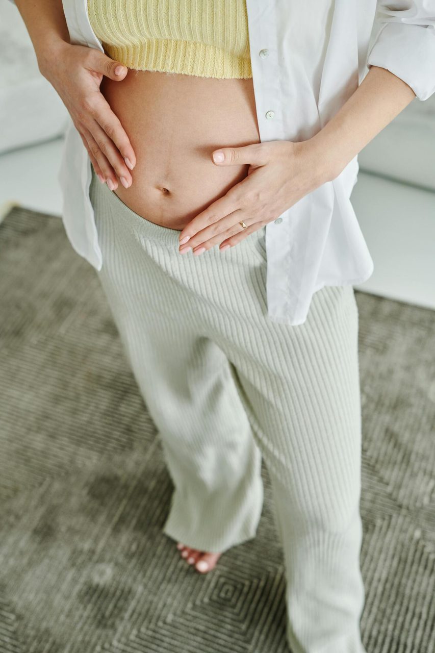 A serene close-up of a woman gently holding her pregnant belly, expressing motherhood.. Matilda Wormwood: https://www.pexels.com/@matilda-wormwood