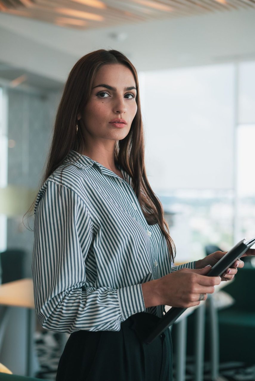 Portrait of a businesswoman holding documents in a modern office.. Los Muertos Crew: https://www.pexels.com/@cristian-rojas