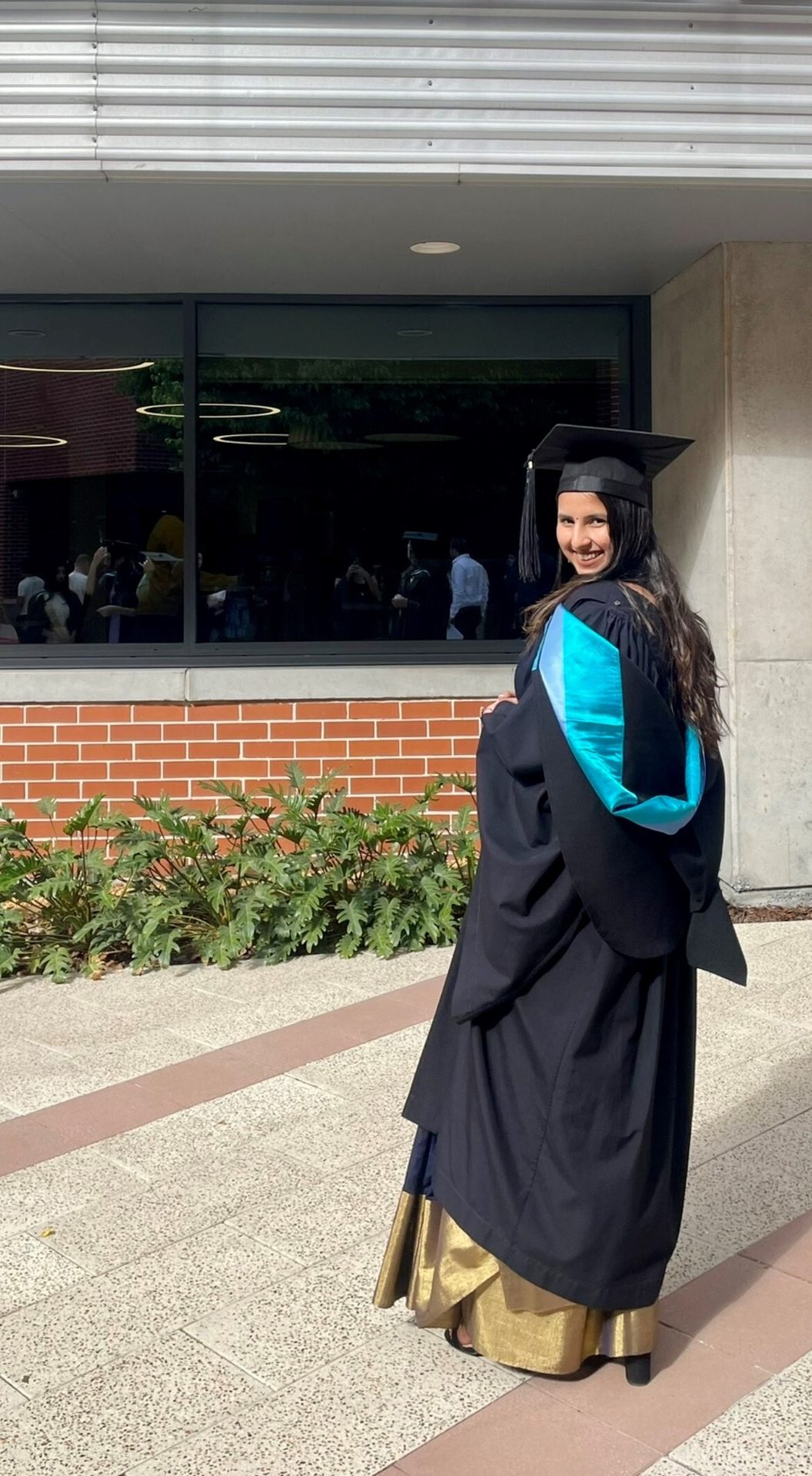 Academic dress, Smile, Plant, Sleeve, Mortarboard, Headgear, Scholar