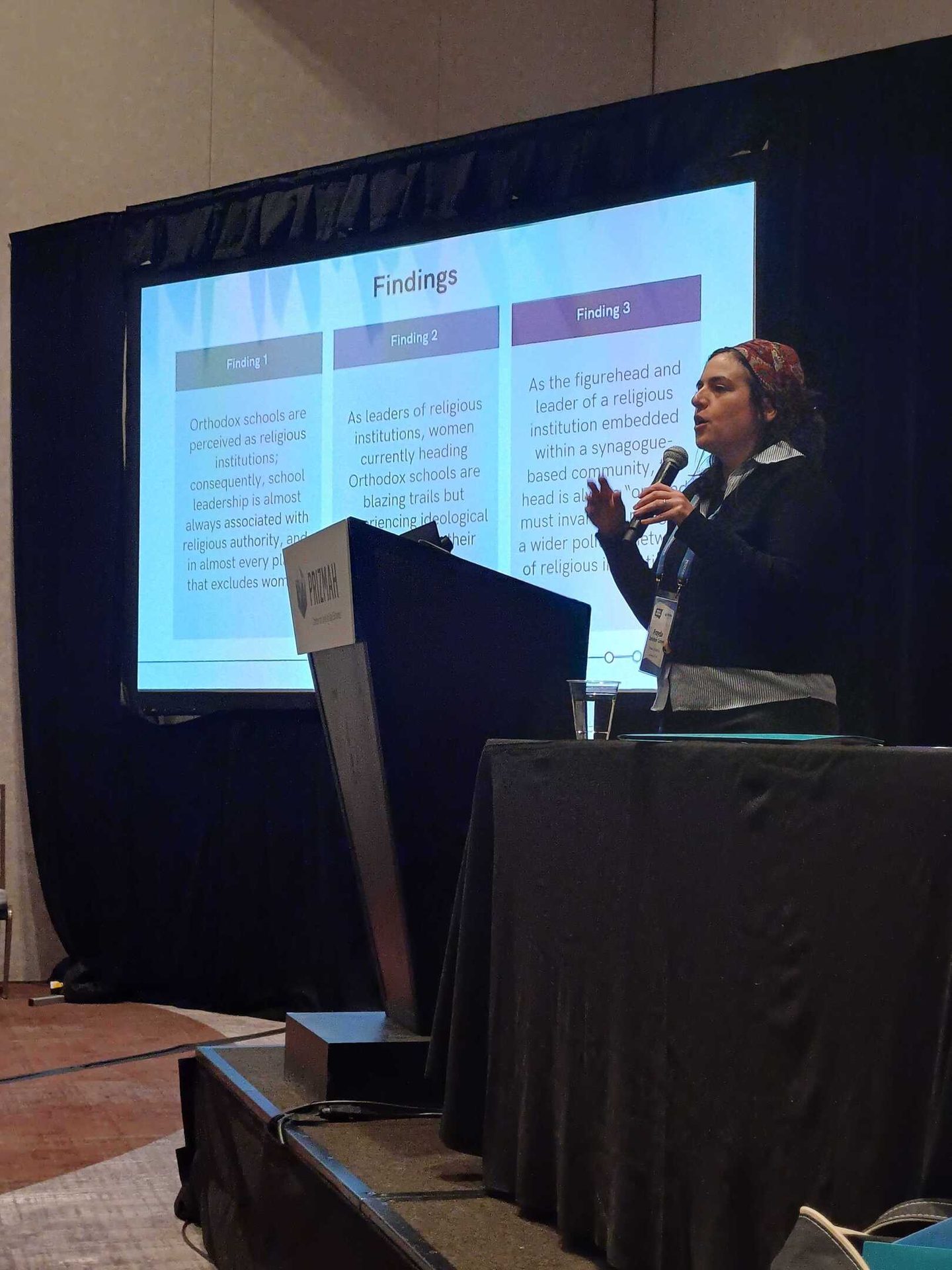 Woman presenting research findings on women's leadership in Orthodox religious institutions.