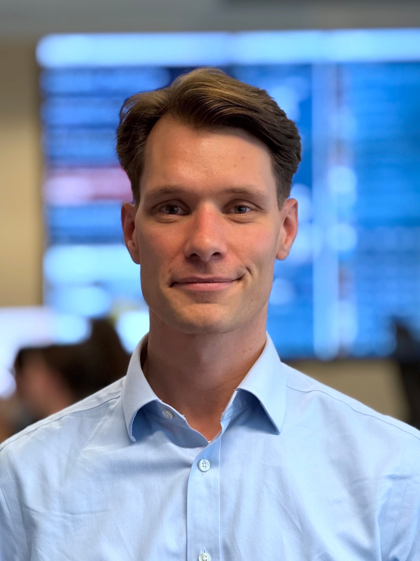 Smiling man in a light blue shirt.