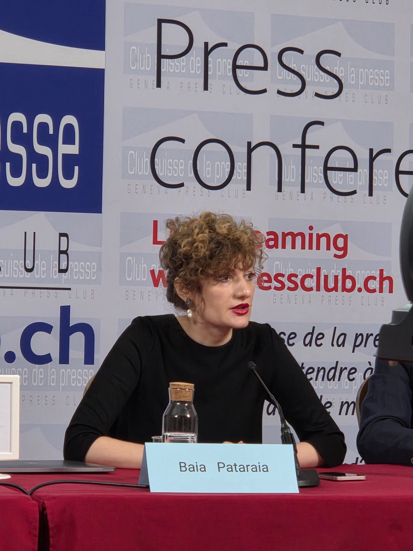 Baia Pataraia, a woman with curly hair, speaks at a press conference.