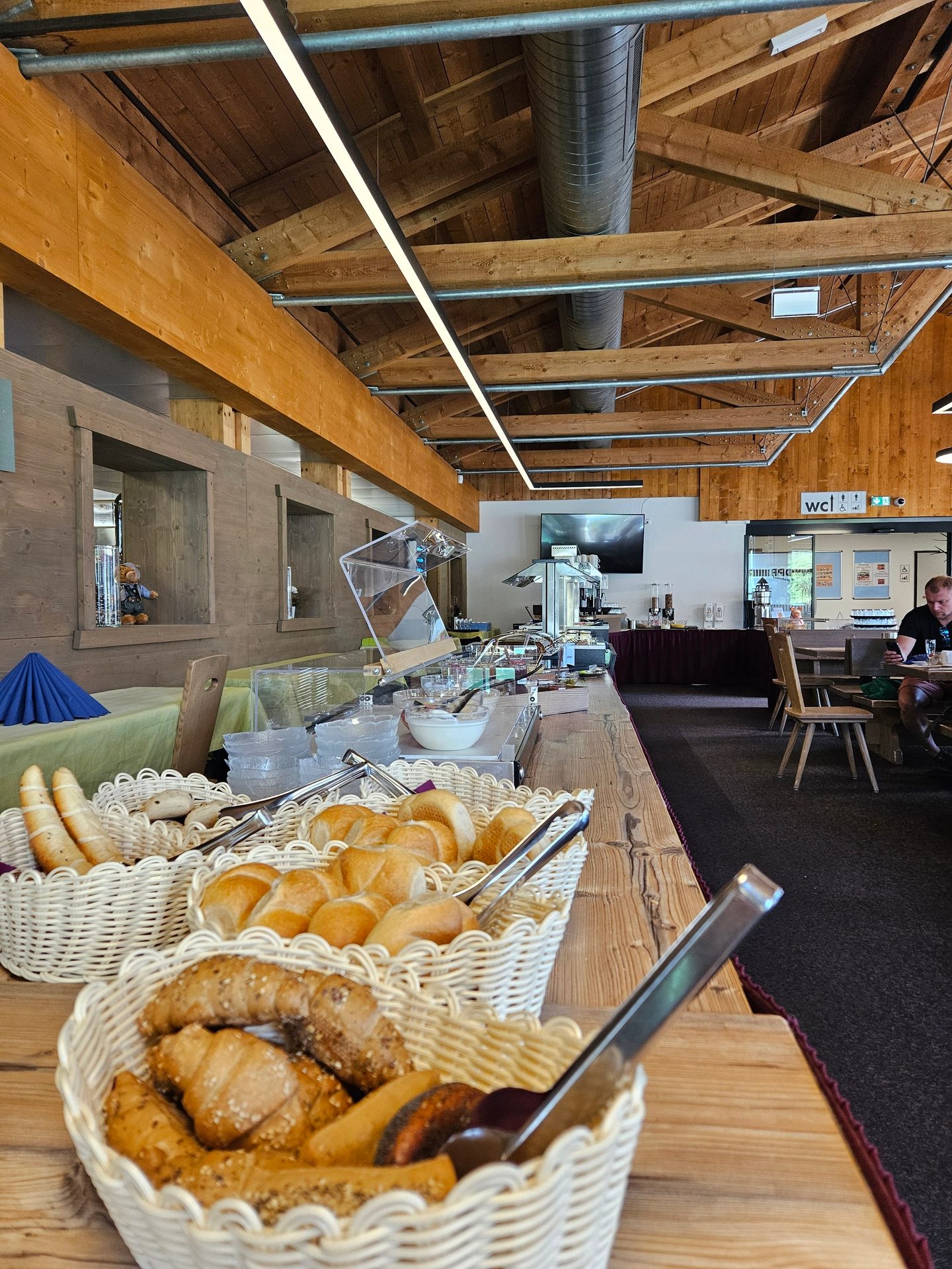 Buffet line with bread baskets in a rustic wooden room.