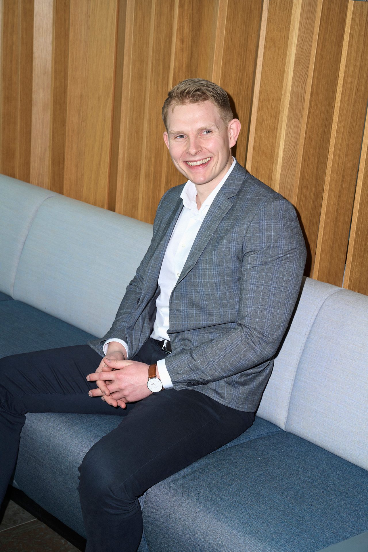 Formal wear, Facial expression, Interior design, Dress shirt, Sleeve, Smile, Shoulder, Collar, Blazer, Standing