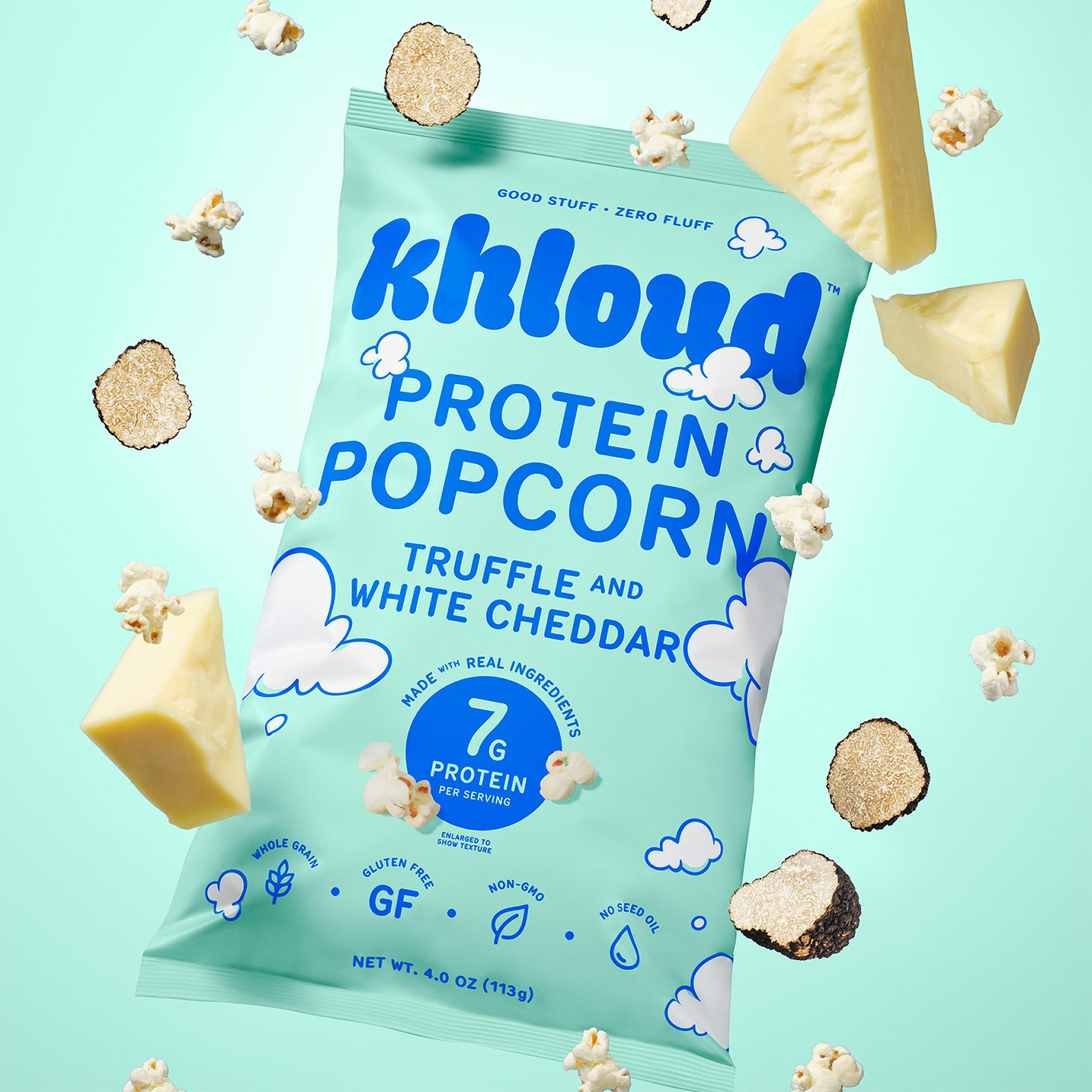 A bag of Khloud Protein Popcorn (Truffle & White Cheddar flavor) surrounded by popcorn, truffle slices, and cheese.