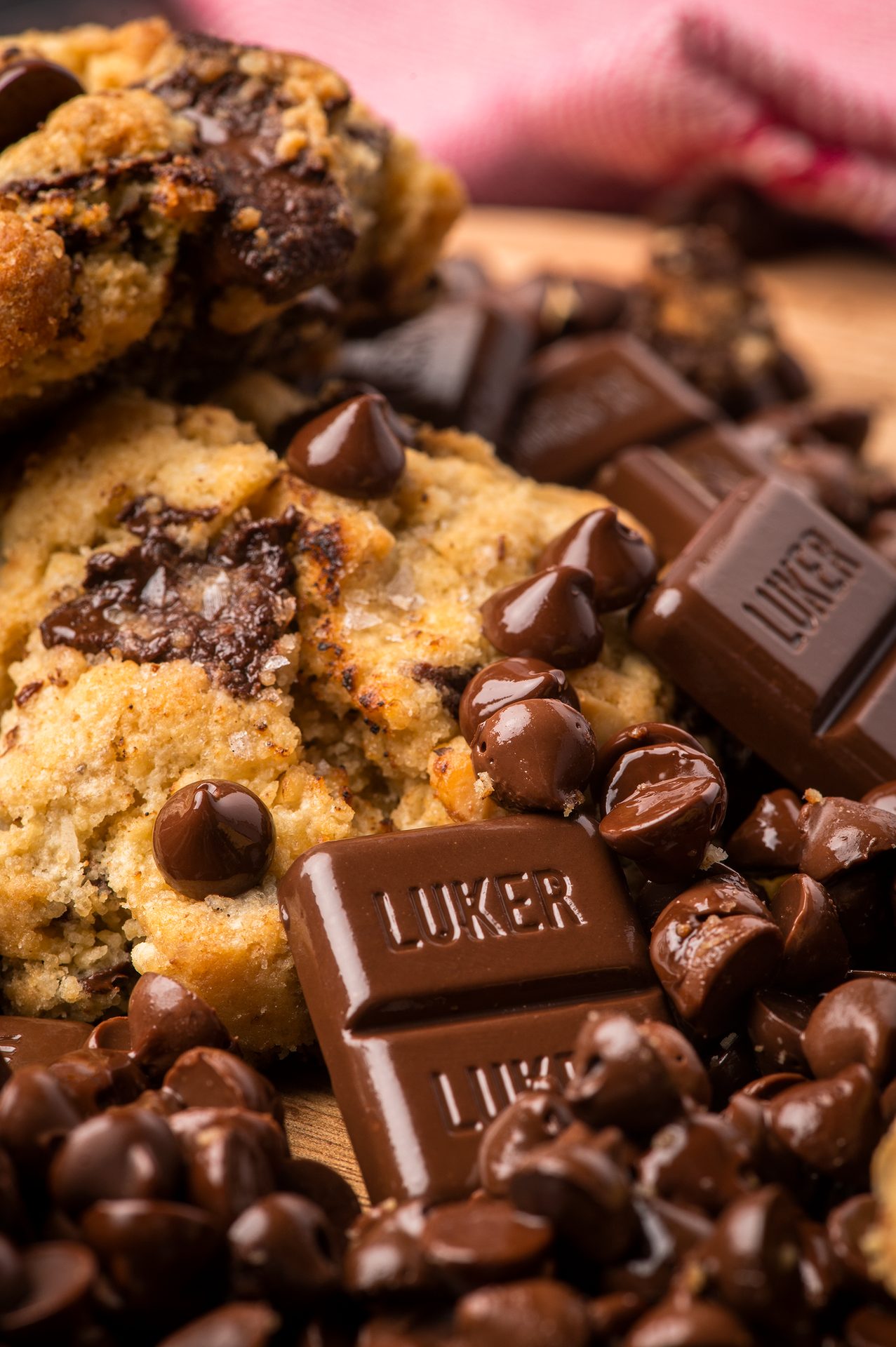 Pile of chocolate chip cookies topped by hunks of Luker Chocolate