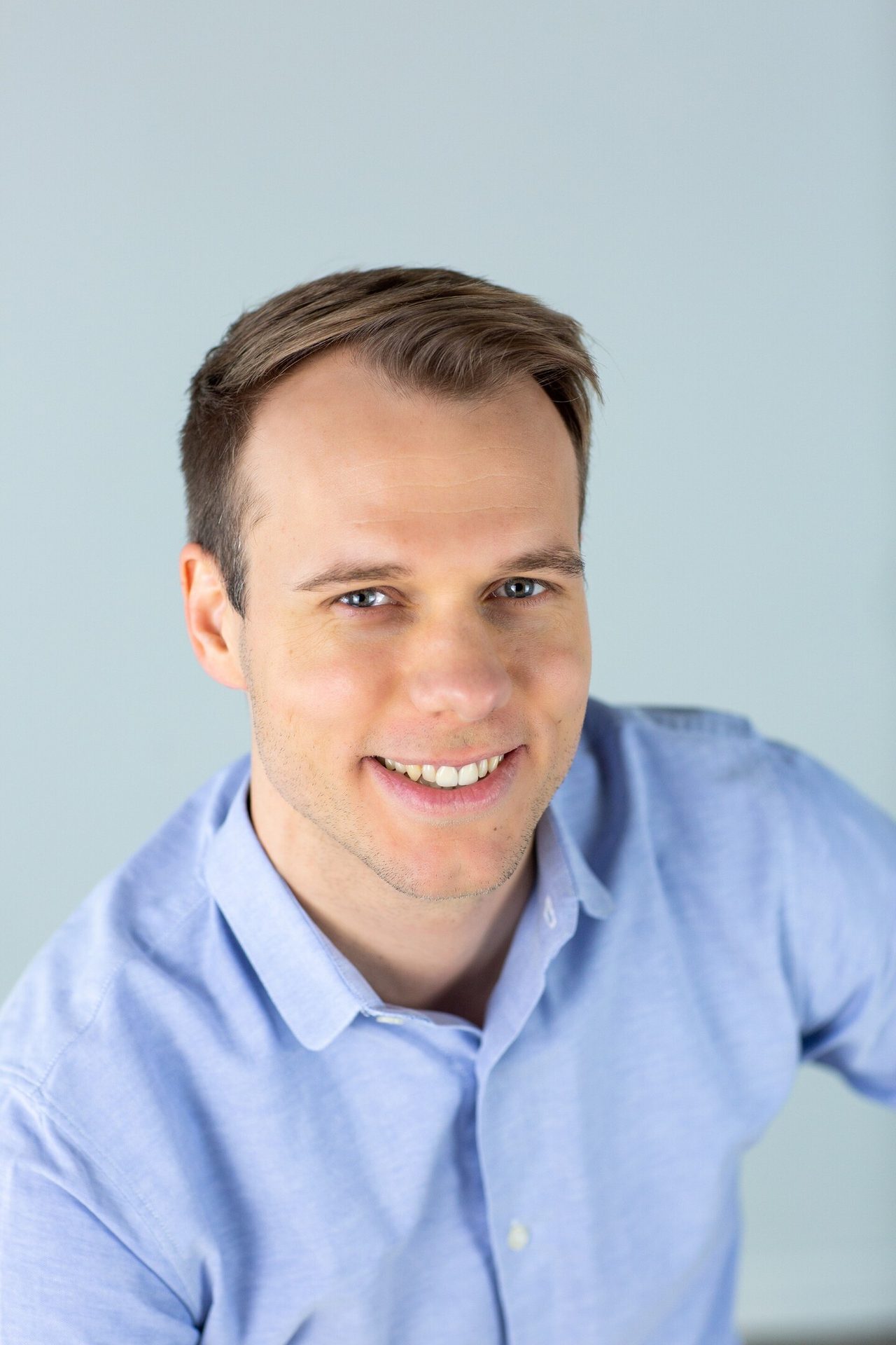 Smiling man in blue shirt.
