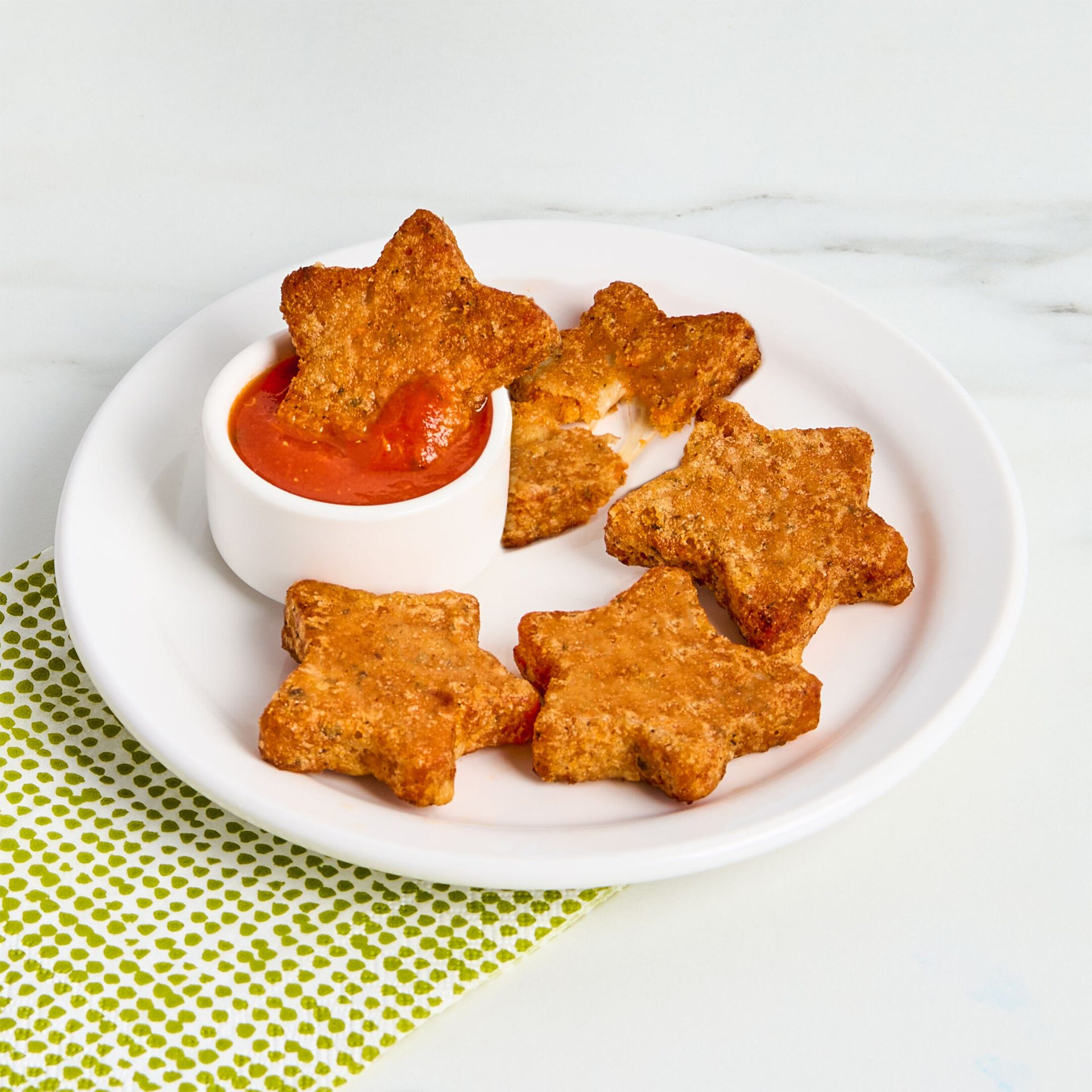 Star-shaped mozzarella sticks on a white plate with marinara sauce.