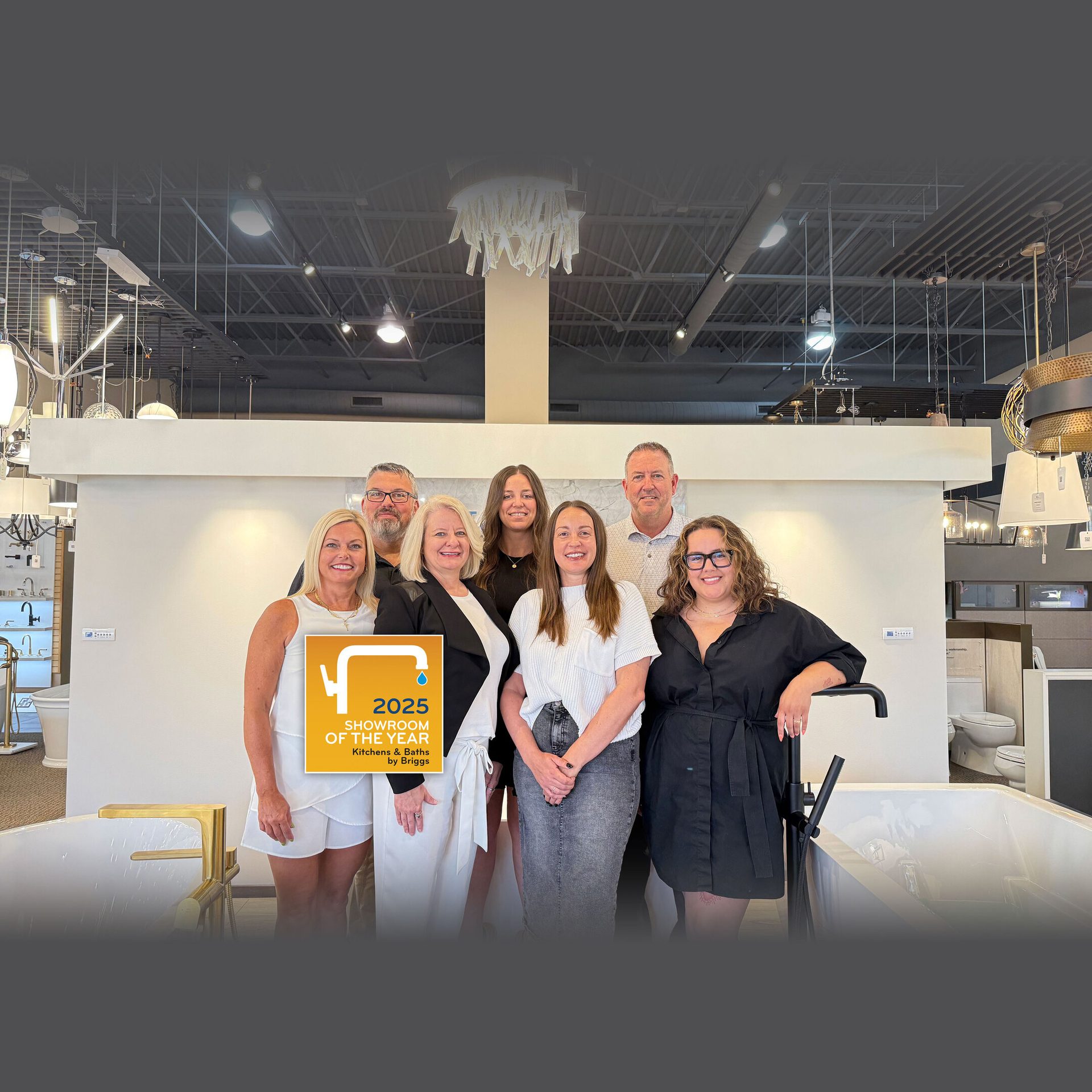 Group photo of 7 people in a showroom with a "2025 Showroom of the Year" award.