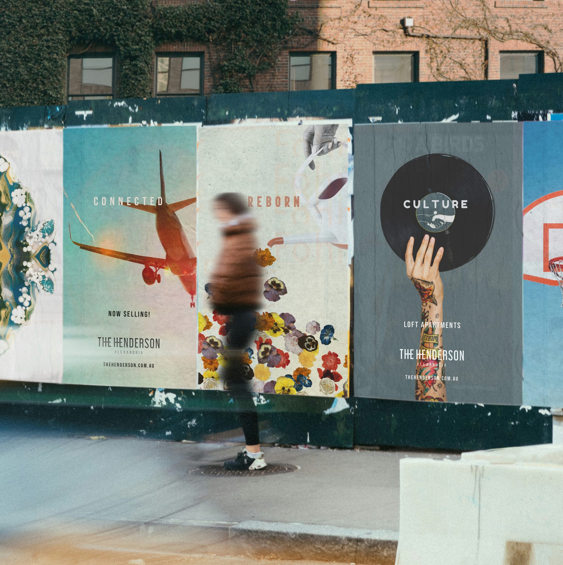Street advertising for "The Henderson" apartments on a wall; a blurred person passes by.