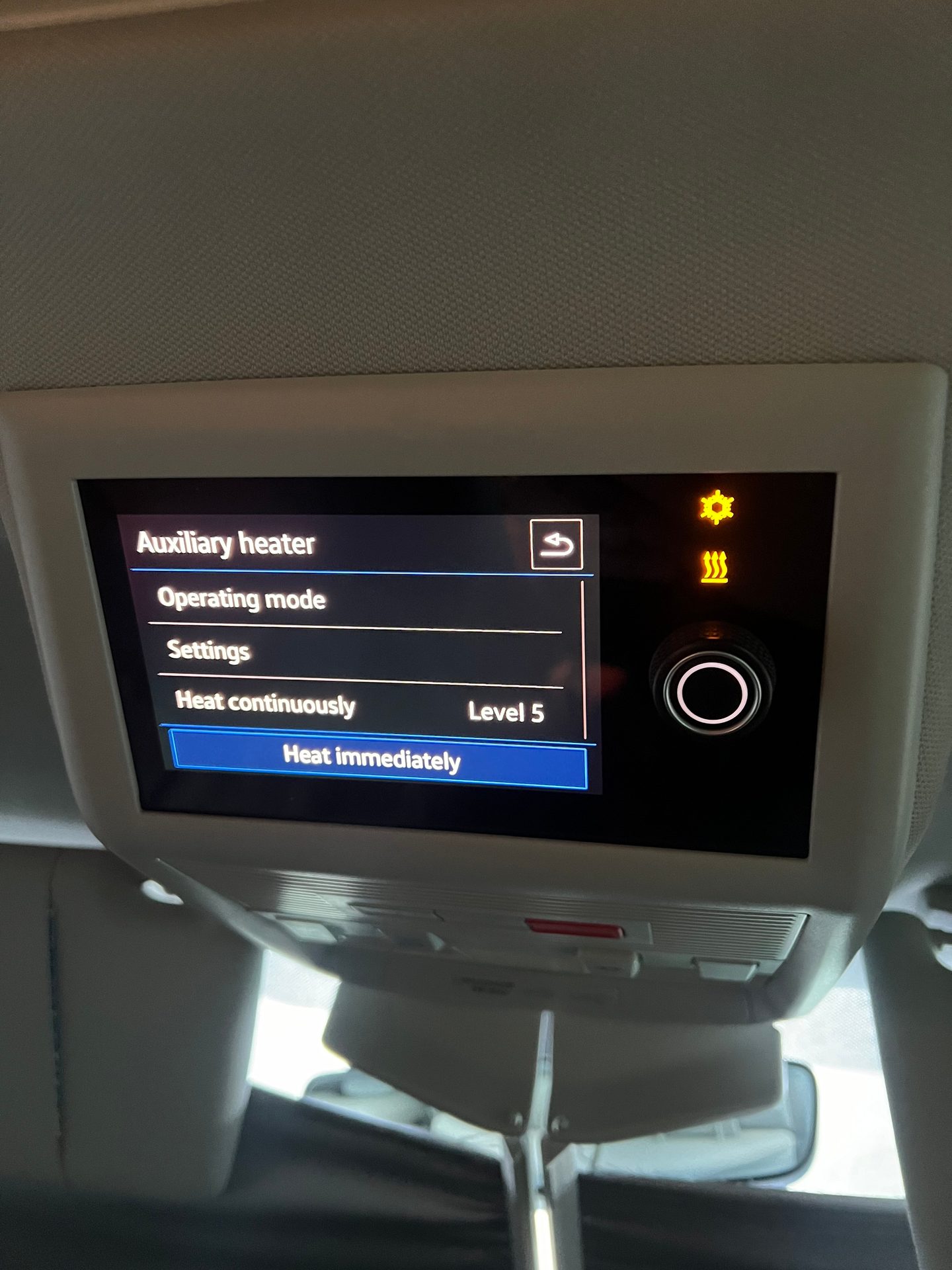 Car overhead display showing auxiliary heater menu and controls.
