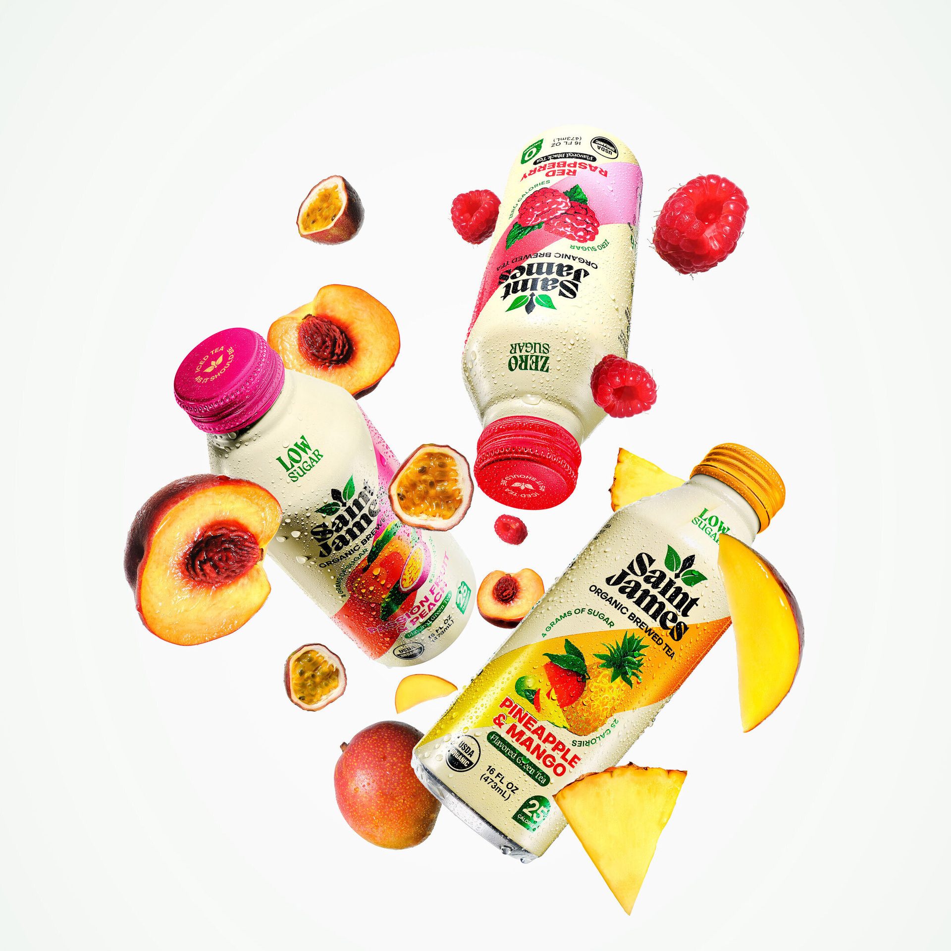 Three Saint James Organic Brewed Tea bottles (Peach, Raspberry, Pineapple Mango) with fresh fruit.