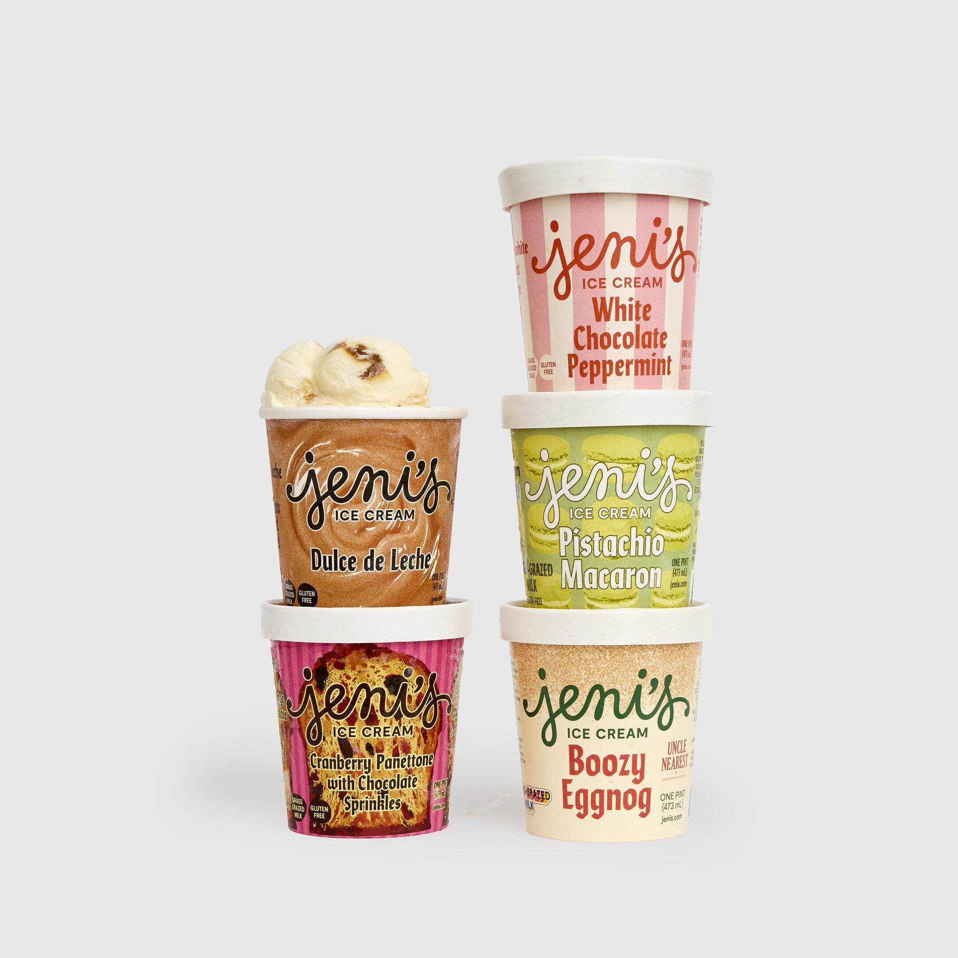 Five Jeni's ice cream pints stacked: Dulce de Leche, White Chocolate Peppermint, and more.