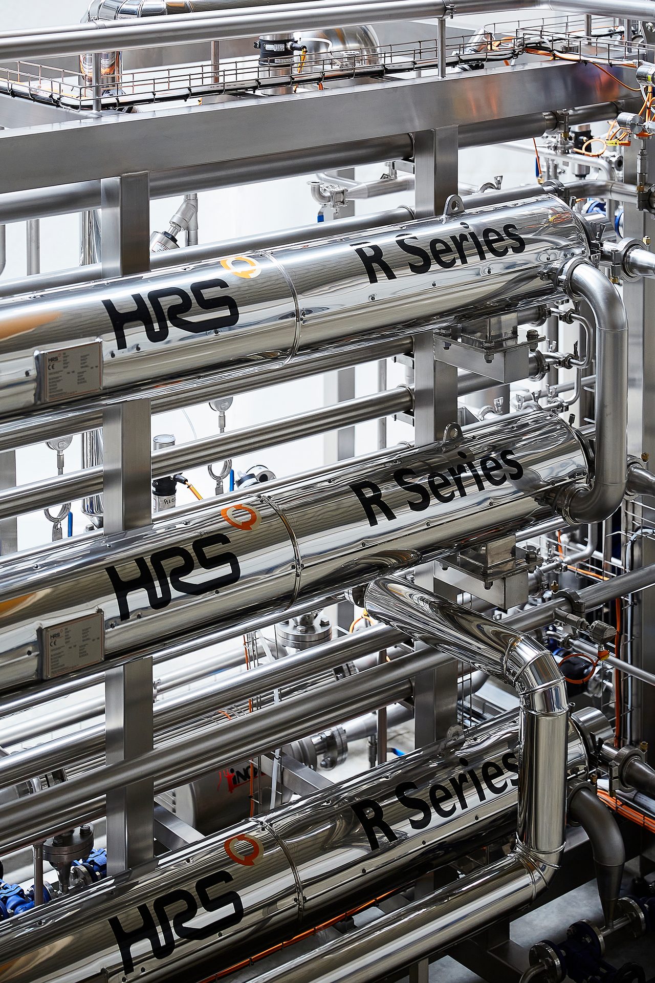 Polished stainless steel industrial pipes labeled 'HRS R Series'.