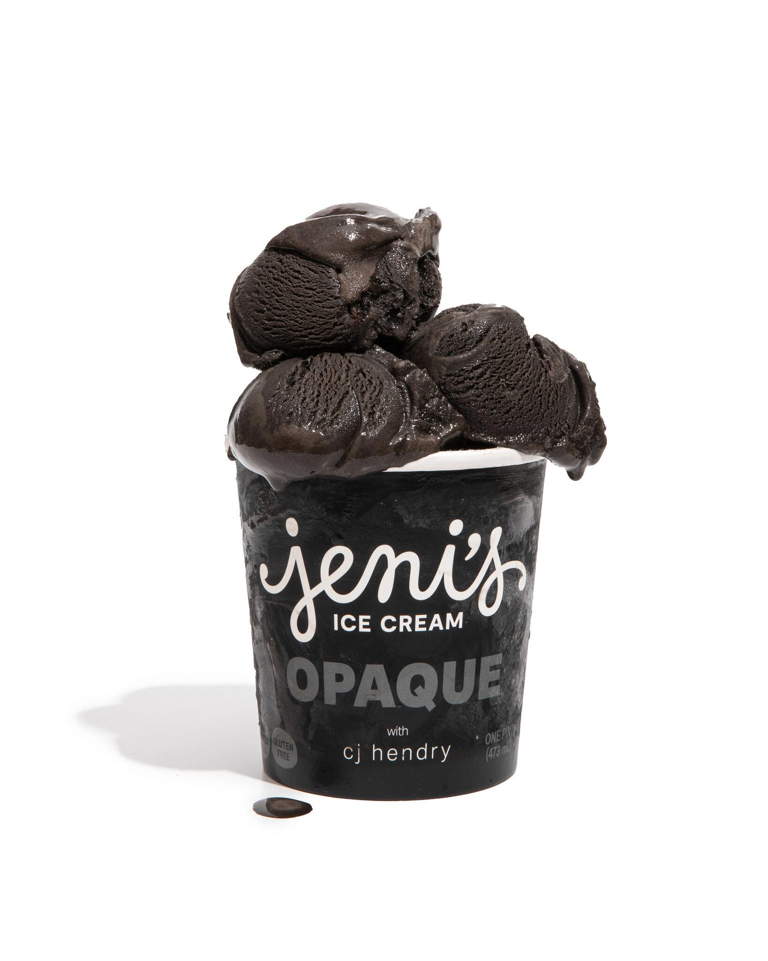 Jeni's pint with black scoops overflowing, melting slightly on a white background.
