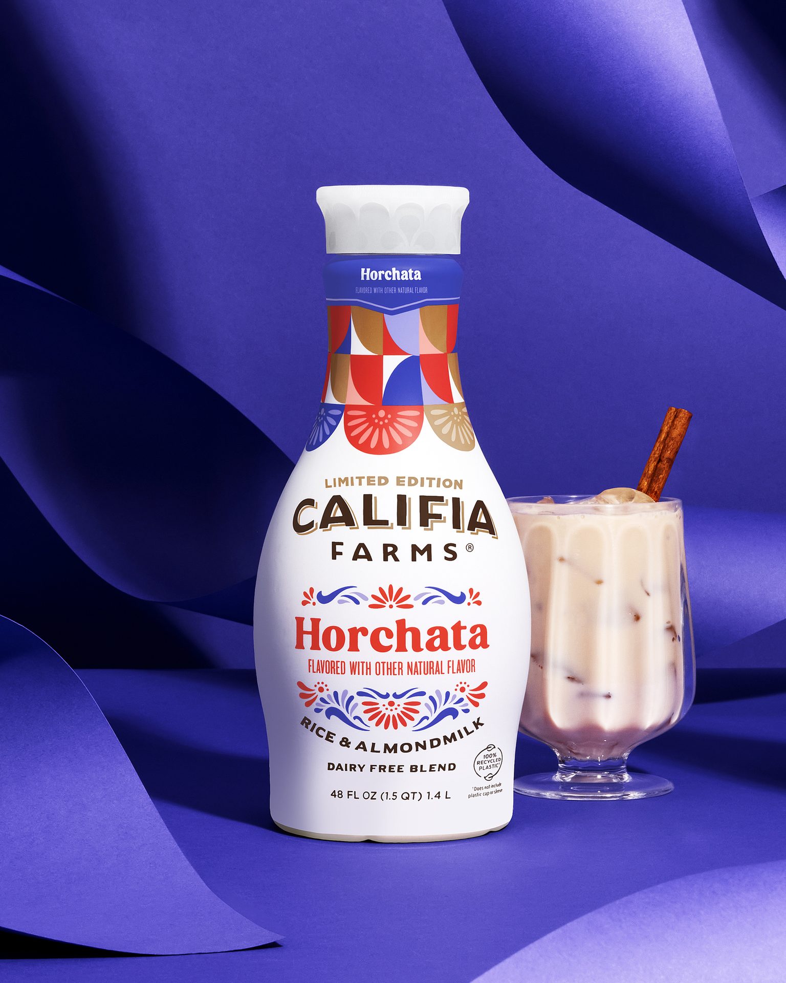 A Califia Farms Limited Edition Horchata bottle next to a glass of horchata with a cinnamon stick.
