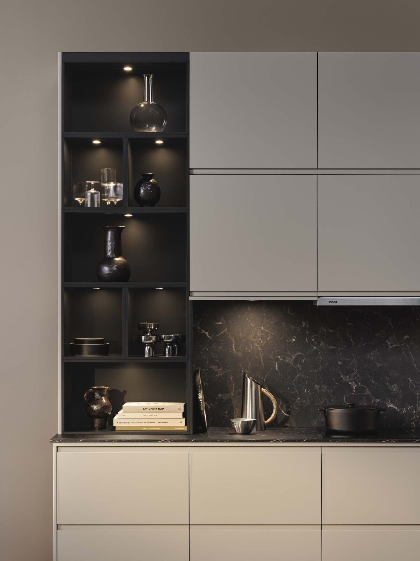 Modern kitchen with light grey cabinets, dark shelves, marble backsplash, and under-cabinet lighting.