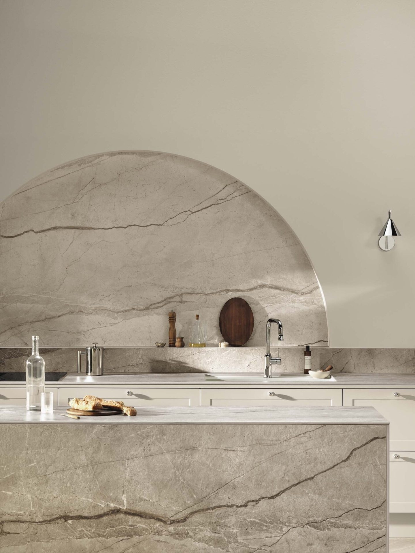 Elegant kitchen featuring a large arched marble backsplash and matching island/countertops.