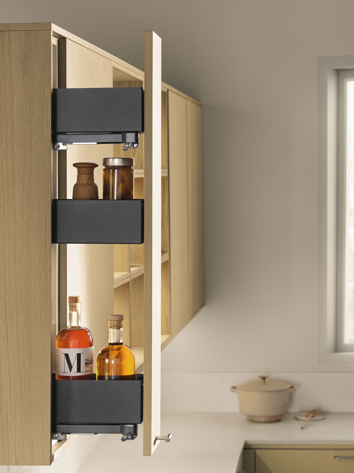 Three black pull-out shelves in a light wood kitchen cabinet, holding bottles and jars.