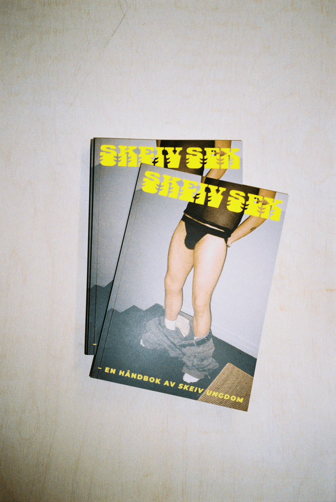 Two copies of a magazine/book titled 'SKEIV SEKS' featuring a person in underwear with pants around their ankles.