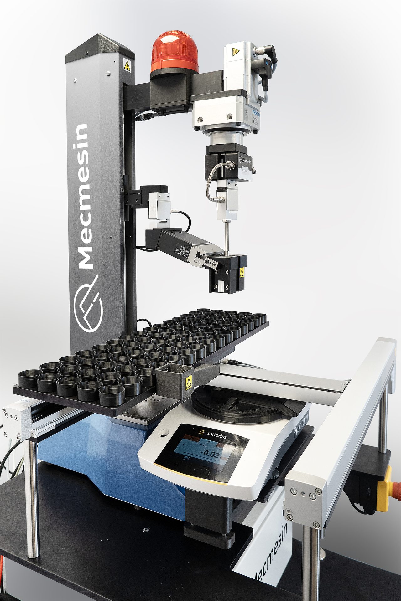 A robotic arm and pneumatic grips synchronized with hand-picking test specimens from a tray of 75 in a single batch run. Additional outboard components (a weighing station) are connected to complete each step in this particular self-contained procedure.