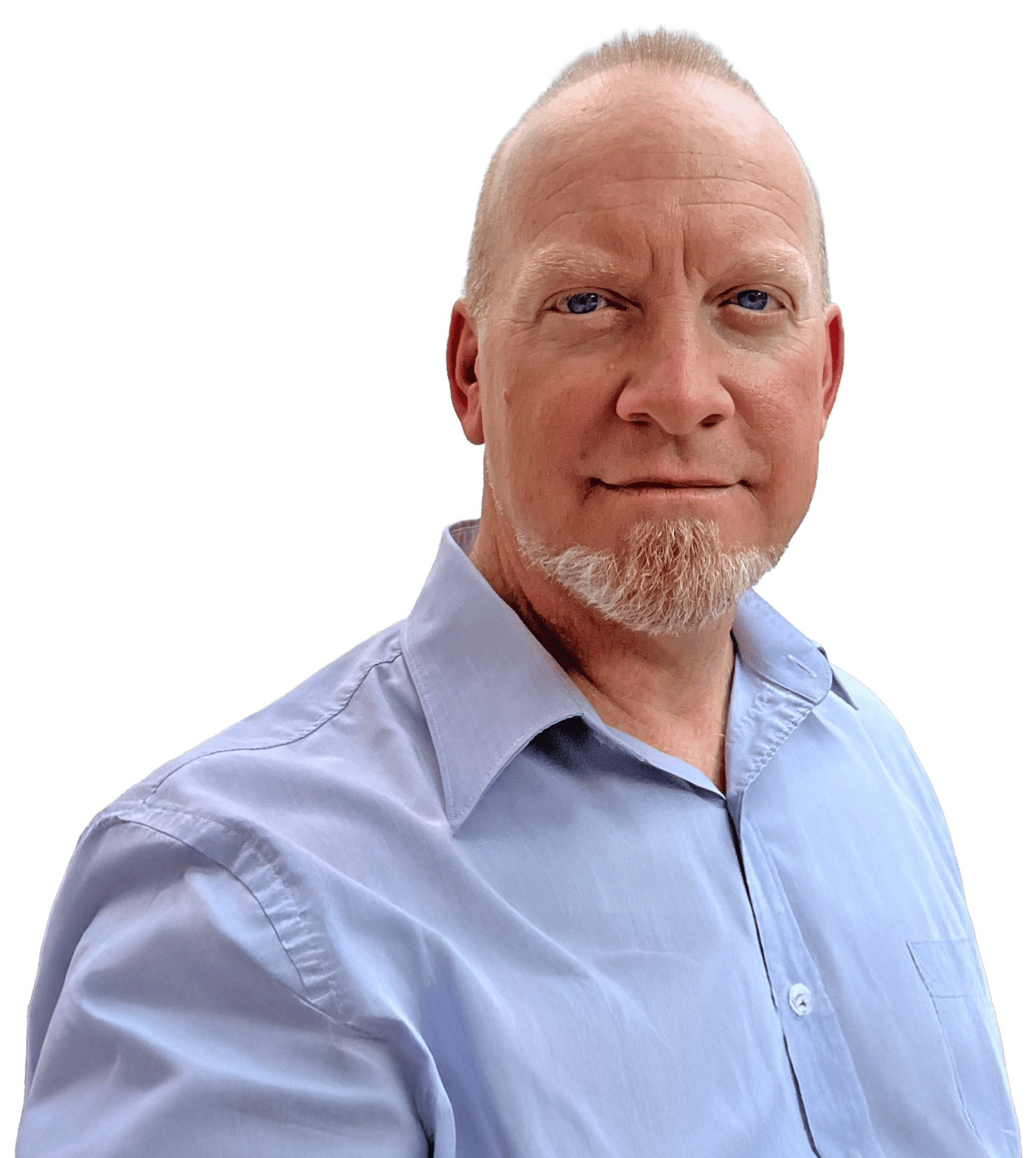 A man with a bald head, white goatee, and blue shirt smiles, looking directly at the camera.
