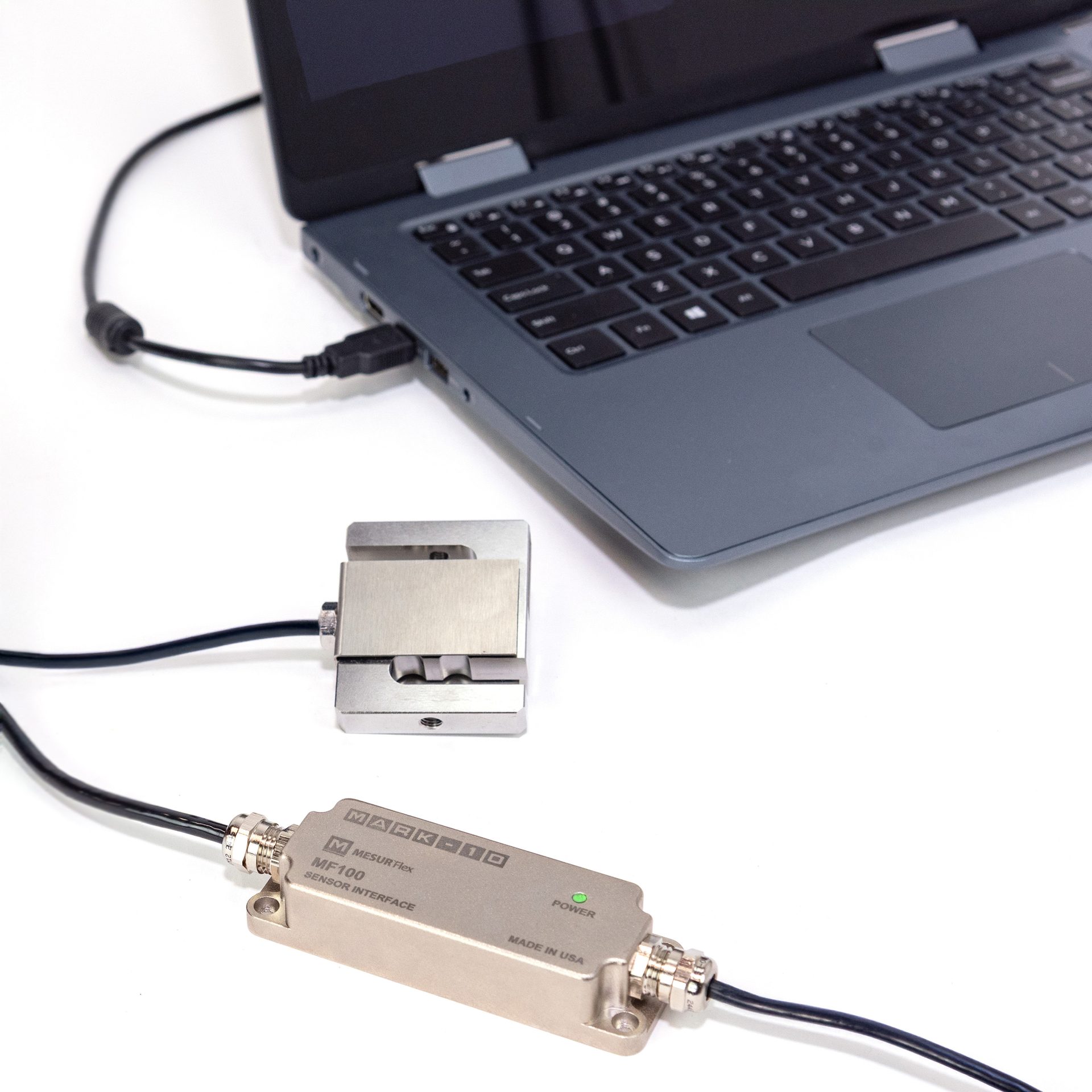 MARK-10 MF100 MESURFlex Sensor Interface connected to a load cell and a laptop via USB.