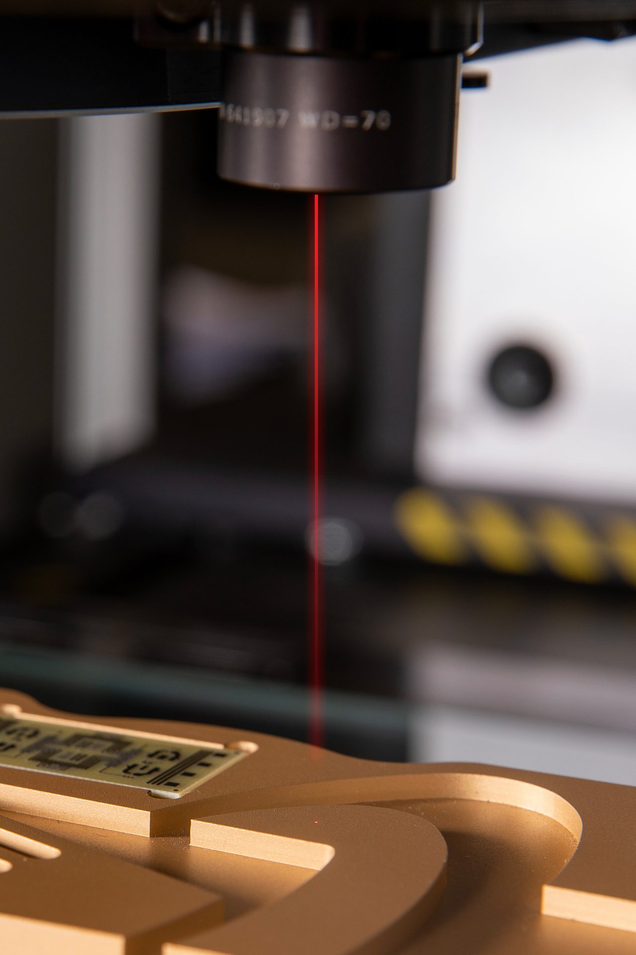 Precision laser beam marking or inspecting a small circuit board held in a golden fixture.