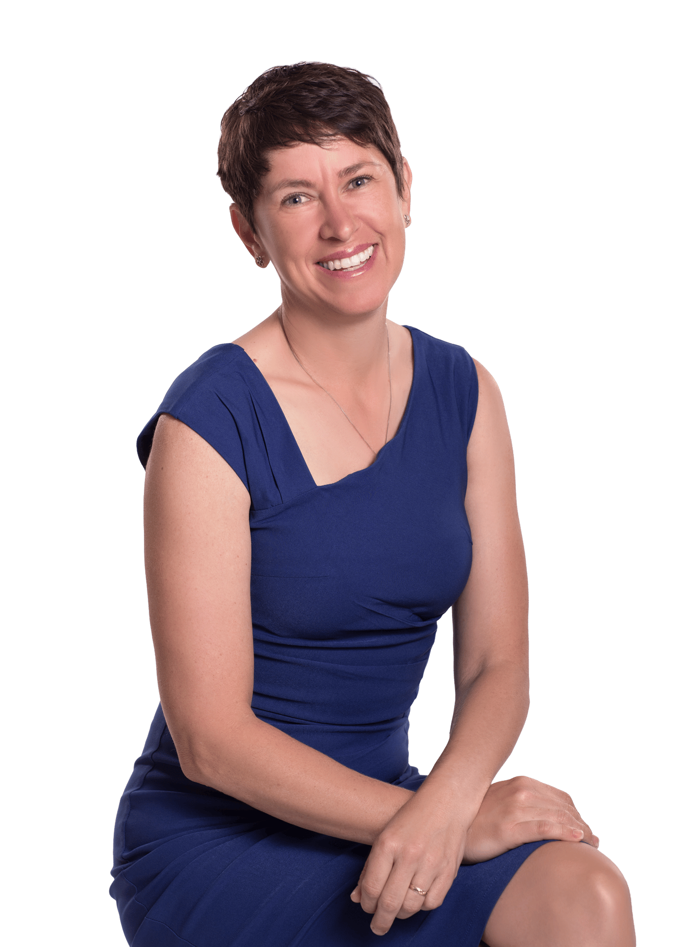 A smiling woman with short brown hair, wearing a blue dress, sitting and looking directly at the viewer.