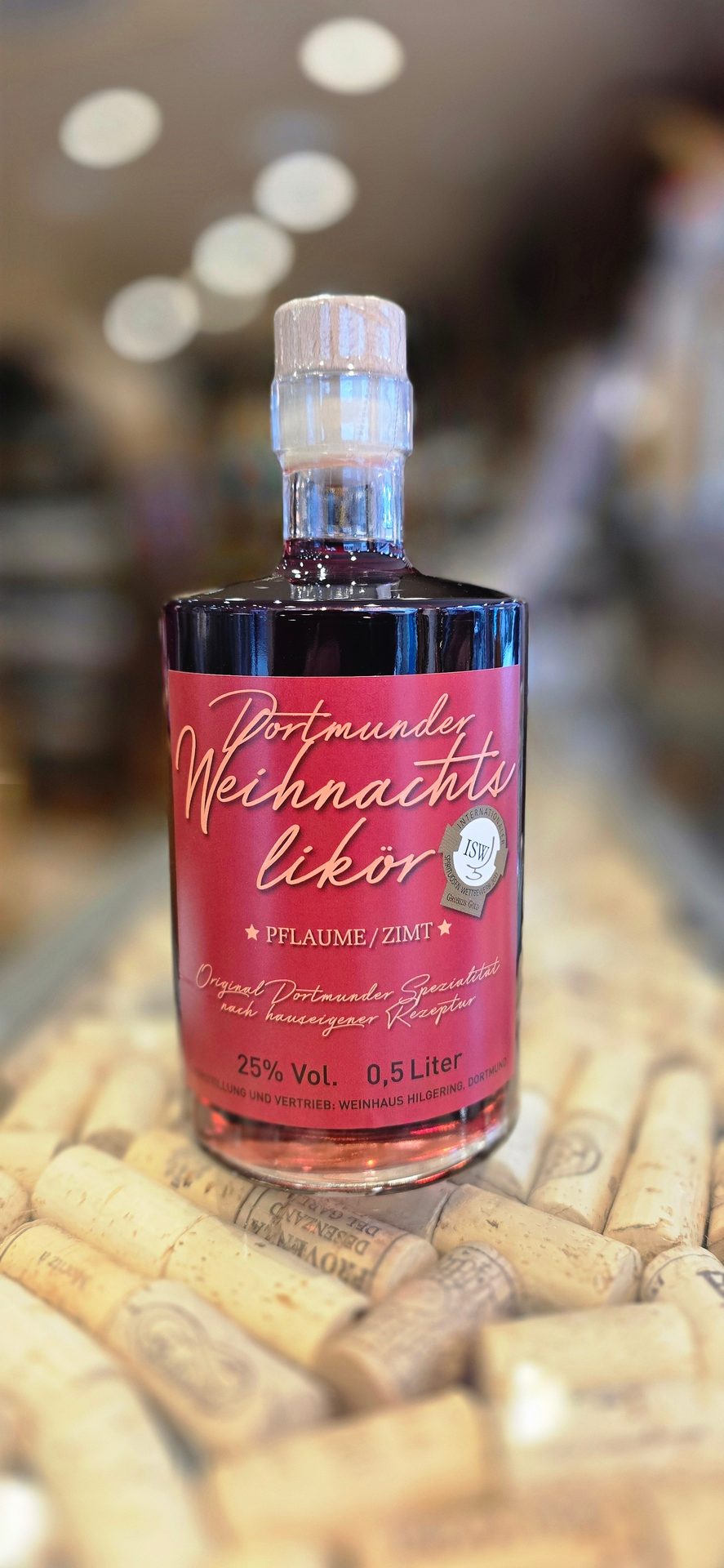 Red-labeled Dortmund Weihnachtslikör (plum/cinnamon) bottle, 25% Vol., 0.5L, on wine corks.