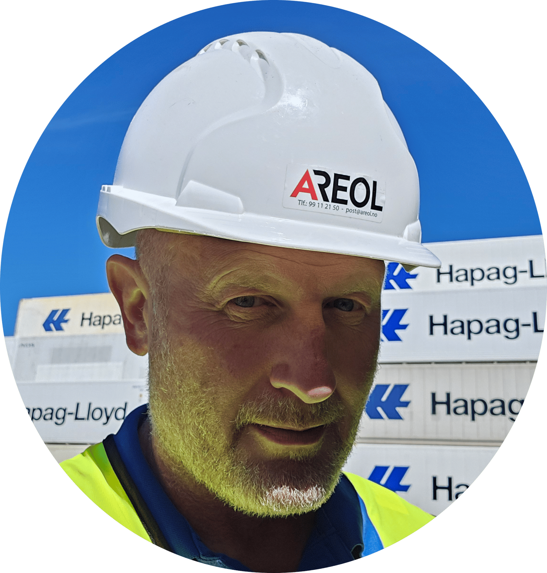 Man in white hard hat and high-vis vest, in front of Hapag-Lloyd containers.