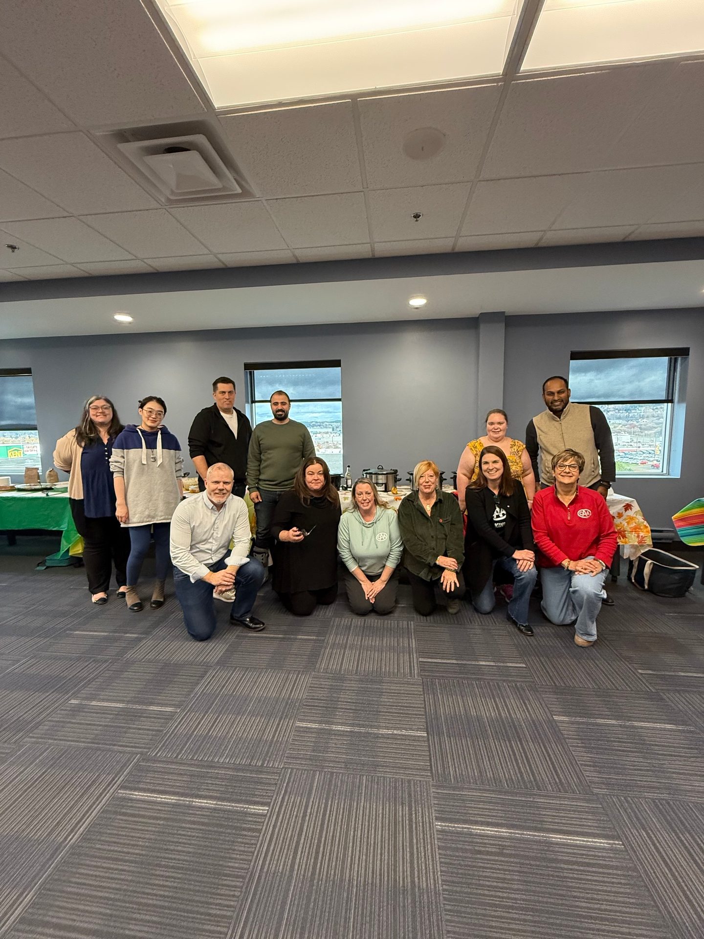 Diverse group of men and women posing in an office.