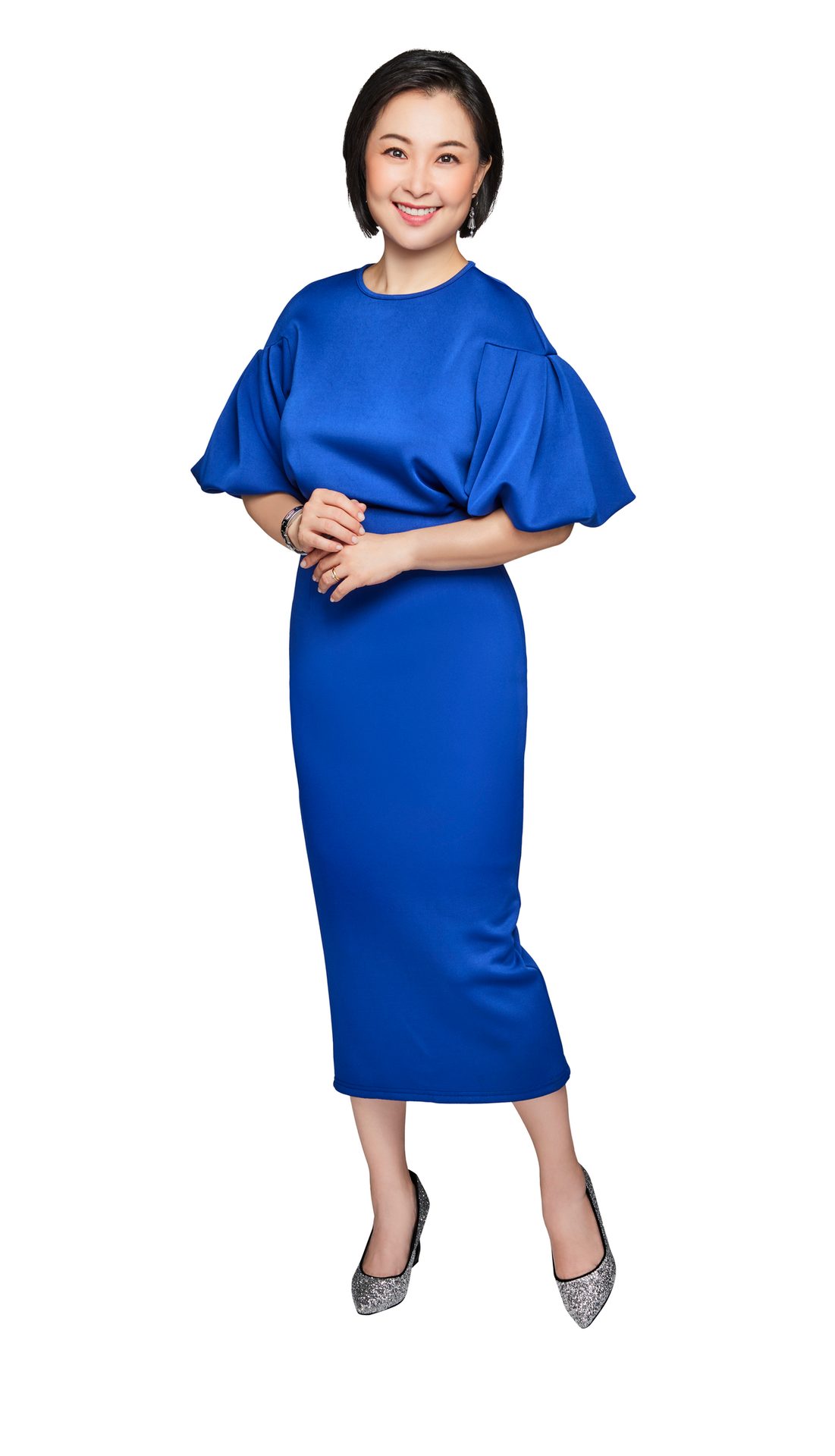 Smiling woman in blue midi dress with puffy sleeves and silver shoes.