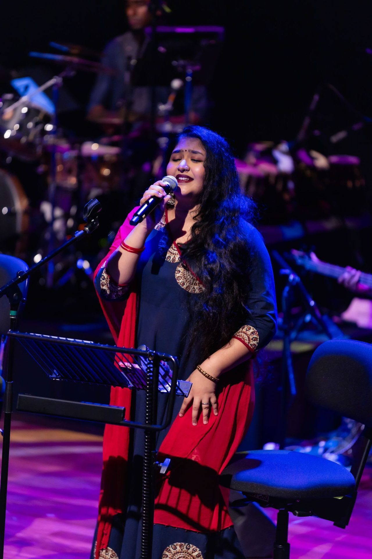 Female singer performs on stage with a microphone.