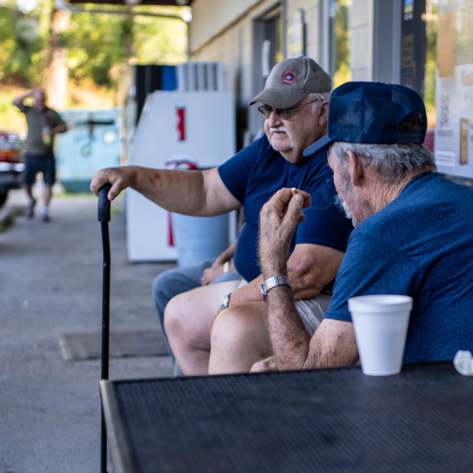 Baseball cap, Arm, T-shirt, Hat, Shorts, Sitting, Elbow, Knee, Muscle