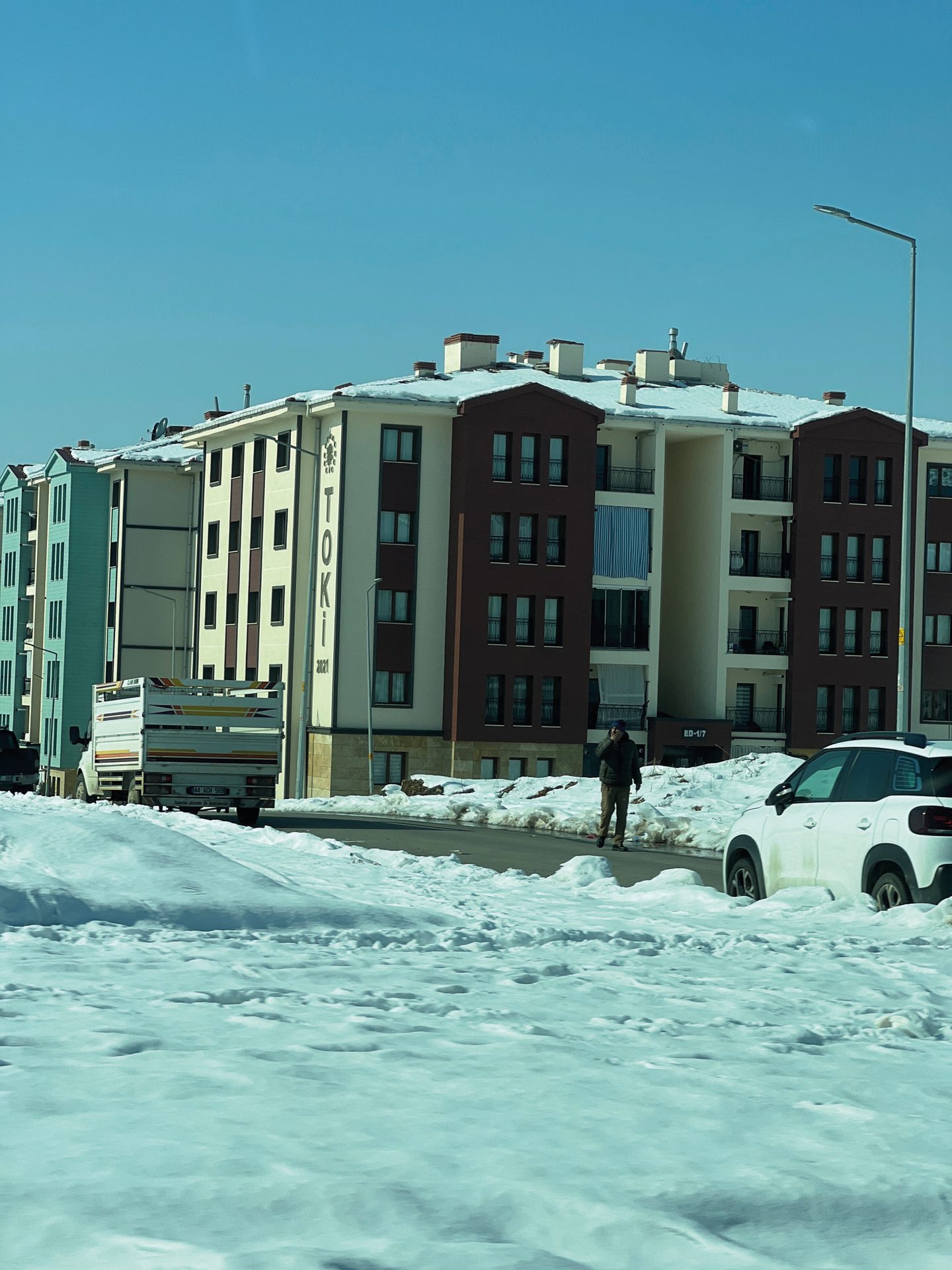 Street light, Urban design, Building, Sky, Window, Snow, Car, Water, Wheel, Tire