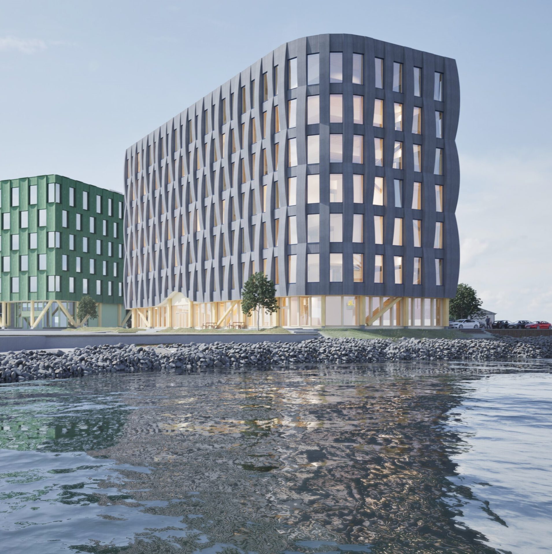 Modern green and grey buildings by water, reflecting in the waves.