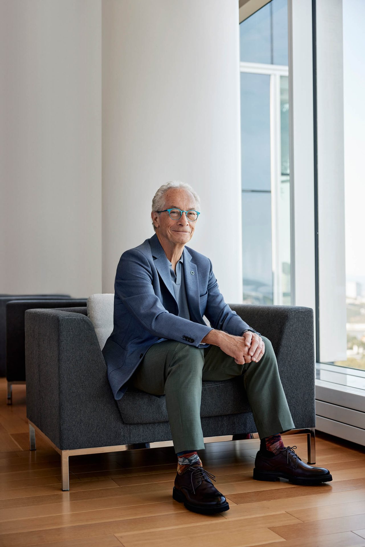Dress shirt, Glasses, Furniture, Leg, Comfort, Sleeve, Grey, Collar, Knee, Flooring