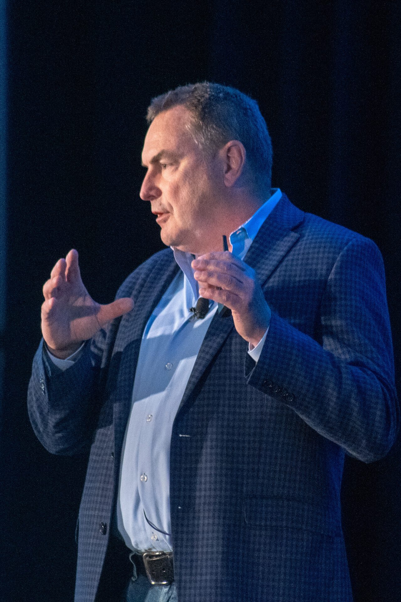 Dress shirt, Audio equipment, Clothing, Chin, Hand, Gesture, Spokesperson, Collar, Finger, Entertainment