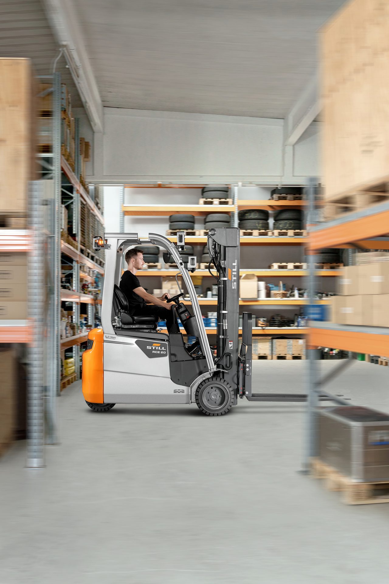 Person operating moving forklift in warehouse.