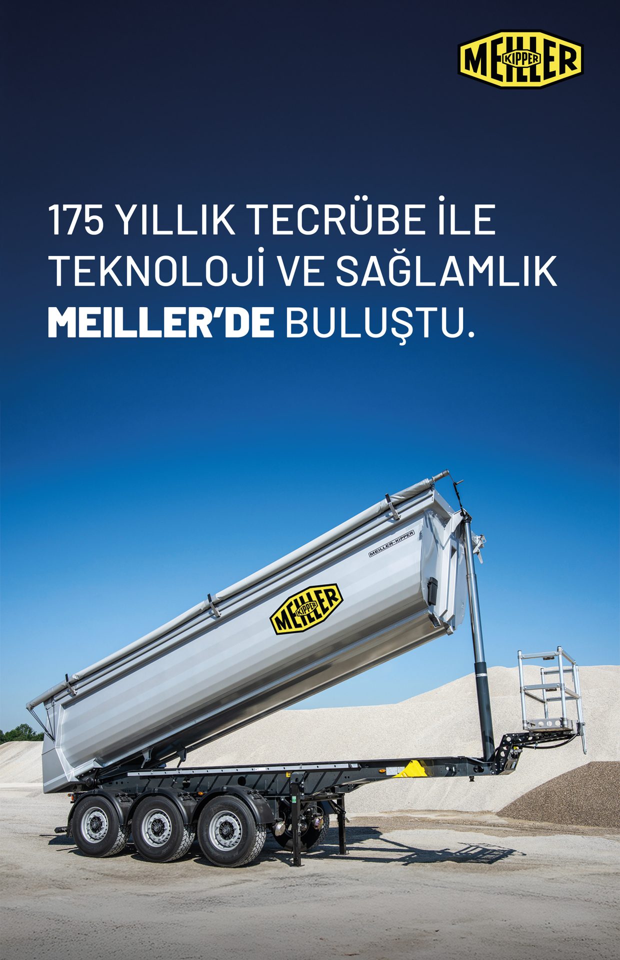 Grey Meiller Kipper dump trailer tilted for unloading, in a gravel quarry.