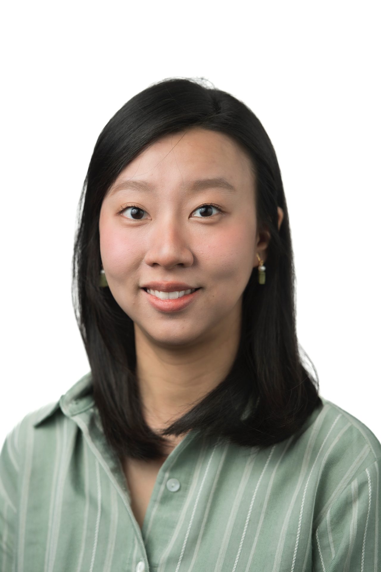 Smiling East Asian woman with dark hair wearing a green striped shirt.