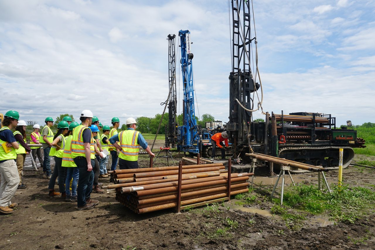 High-visibility clothing, Hard hat, Sky, Cloud, Plant, Vehicle, Workwear, Tire, Asphalt, Tree