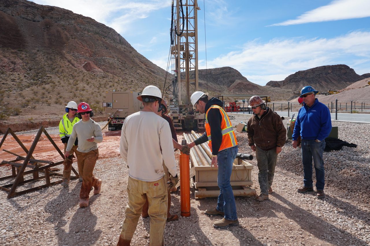 Hard hat, Footwear, Cloud, Sky, Ecoregion, Mountain, Shorts, Asphalt, Headgear, Travel