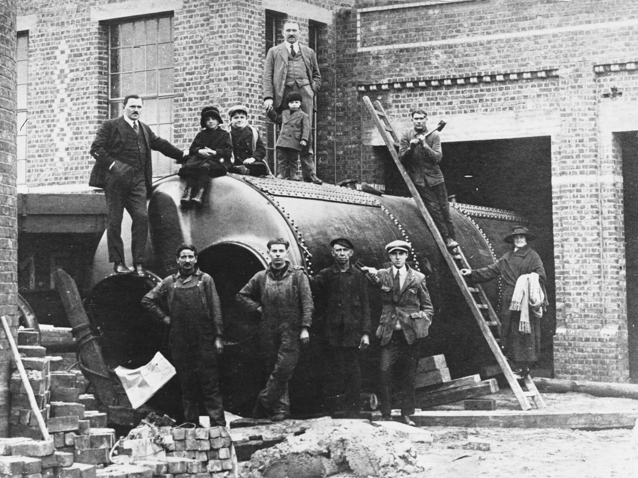 Vintage photograph, Black and white, Workers, Large metal drum, Brick, Ladder