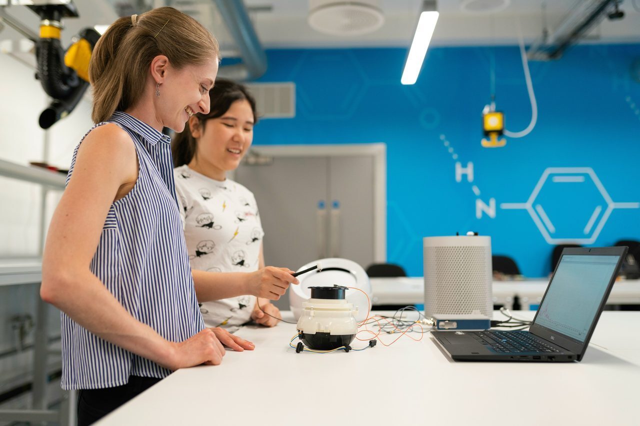 Female noise and vibration engineer oversees student testing vibrations through software