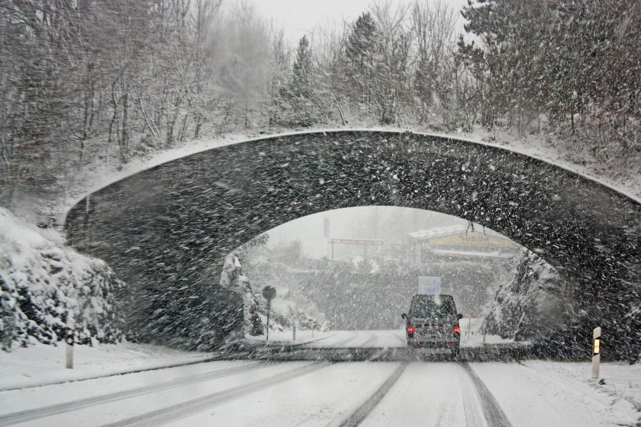 A winter storm covers a Swiss bridge in snow, creating a beautiful yet hazardous landscape.. Magda Ehlers: https://www.pexels.com/@magda-ehlers-pexels