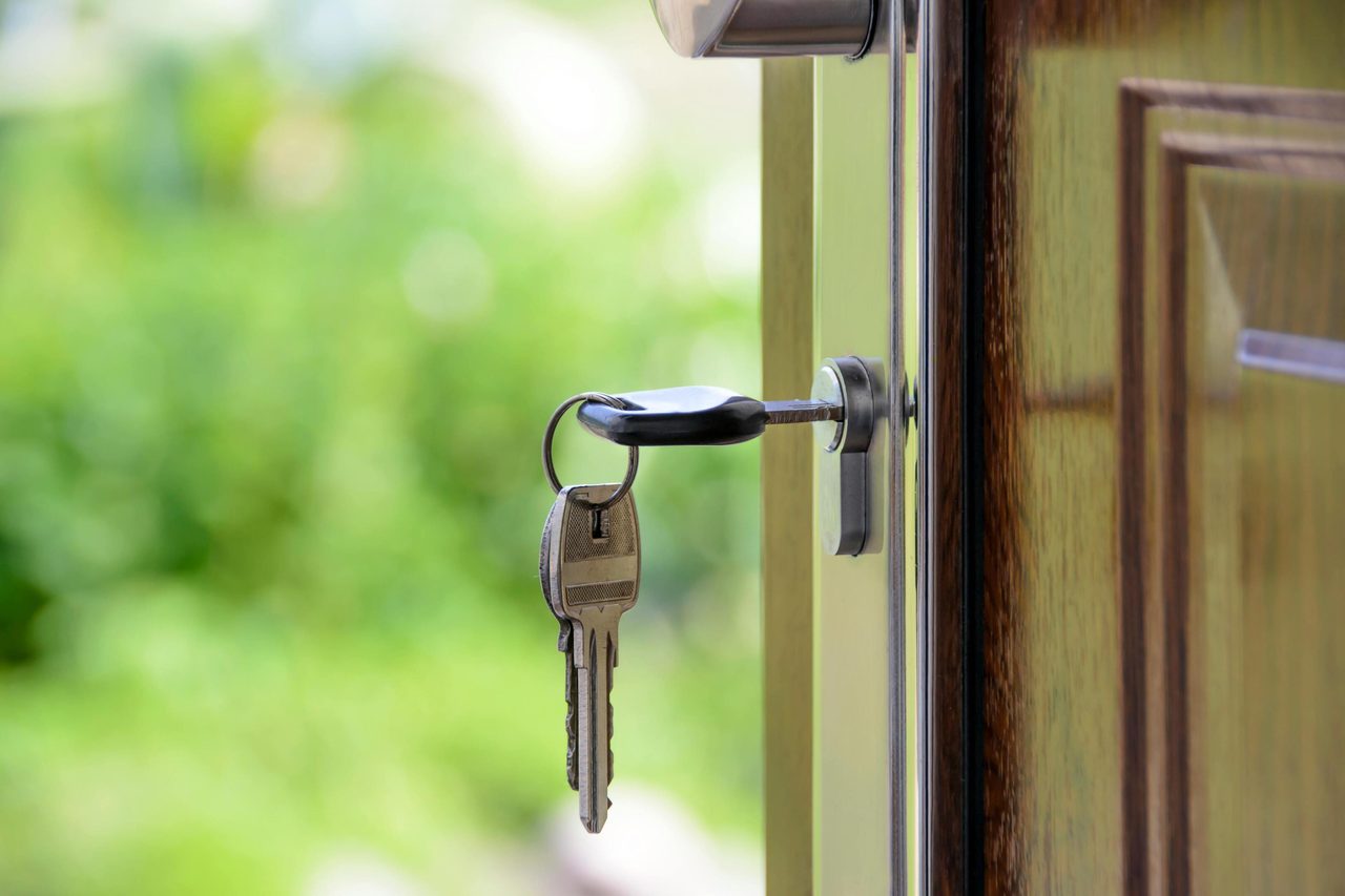 Key inserted in door lock against a blurred green background, symbolizing security and real estate.. AS Photography: https://www.pexels.com/@asphotography