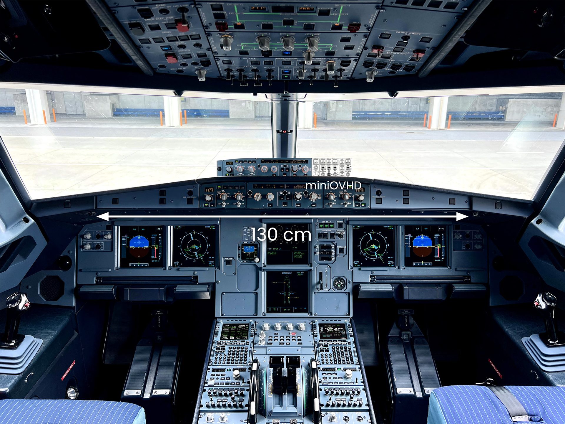 Airplane cockpit showing instruments and controls, with "miniOVHD" and "130 cm" text overlays.