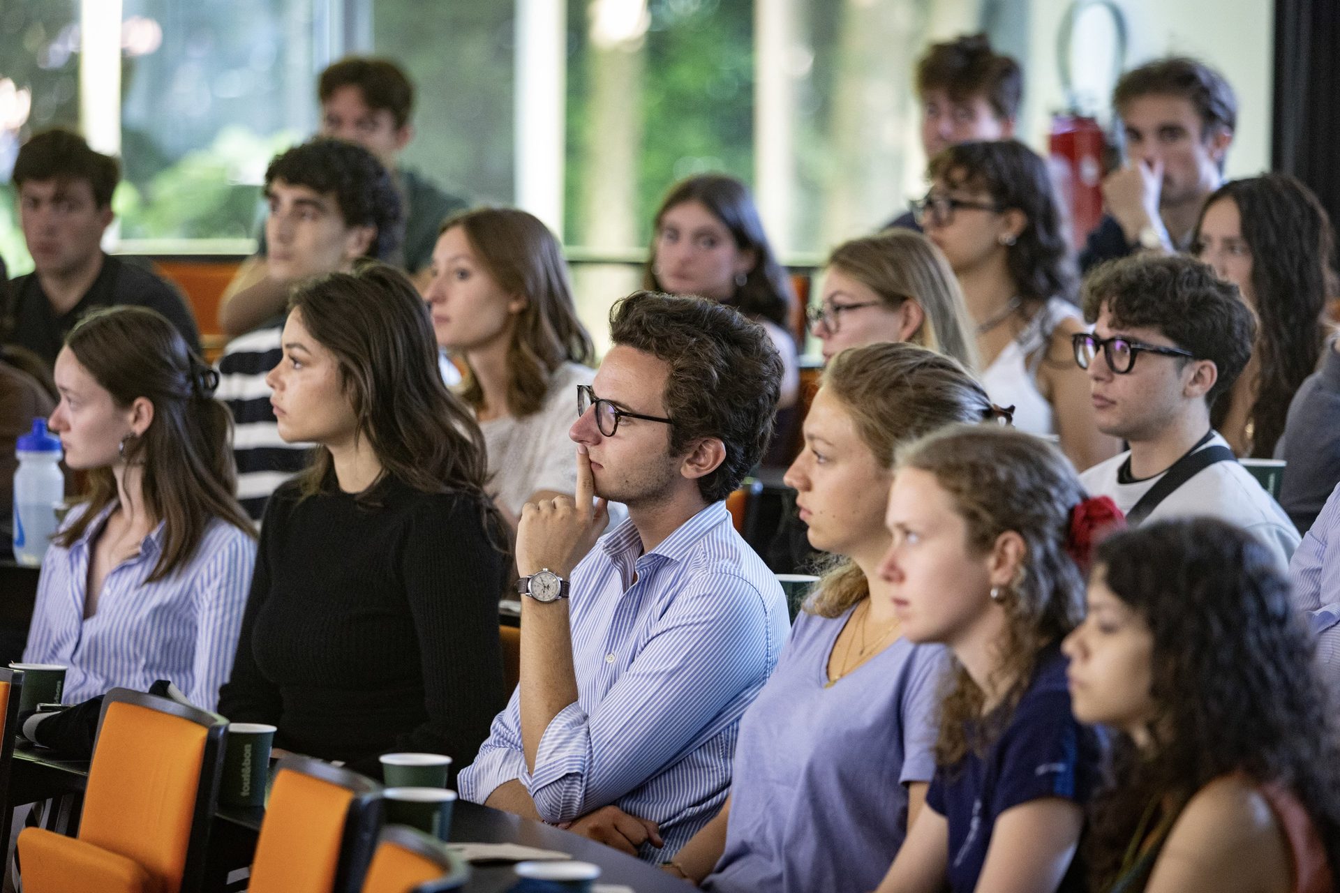 Young adults attentively listening at a conference or lecture.